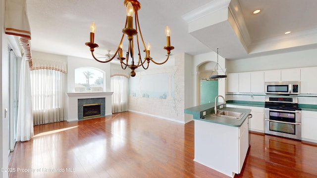 4048 St Ives Blvd, Spring Hill, FL 34609 - kitchen with stainless steel appliances, a sink, a chandelier, wood finished floors, and ornamental molding