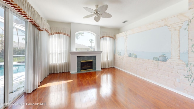 4048 St Ives Blvd, Spring Hill, FL 34609 - unfurnished living room featuring a ceiling fan, wood finished floors, and a fireplace