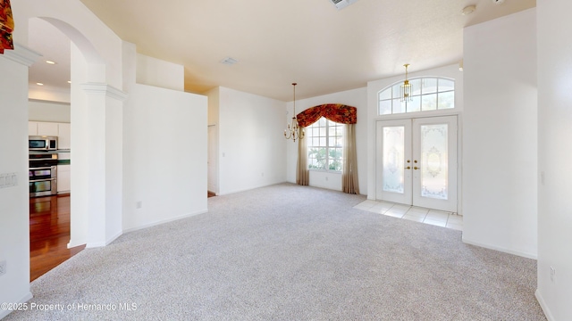 4048 St Ives Blvd, Spring Hill, FL 34609 - unfurnished living room with light carpet, french doors, arched walkways, and a chandelier