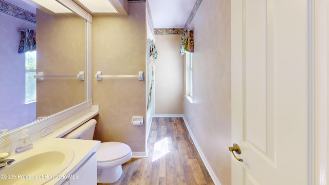 4048 St Ives Blvd, Spring Hill, FL 34609 - bathroom with wood finished floors, toilet, vanity, and baseboards