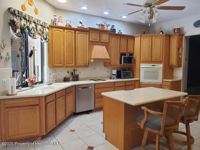 10430 Ramble Ridge Ct, Weeki Wachee, FL 34613 - kitchen with stainless steel appliances, premium range hood, a sink, light countertops, and recessed lighting