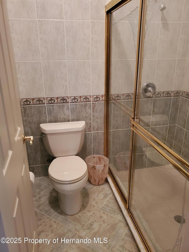 10430 Ramble Ridge Ct, Weeki Wachee, FL 34613 - bathroom with a shower stall, toilet, tile walls, and tile patterned flooring