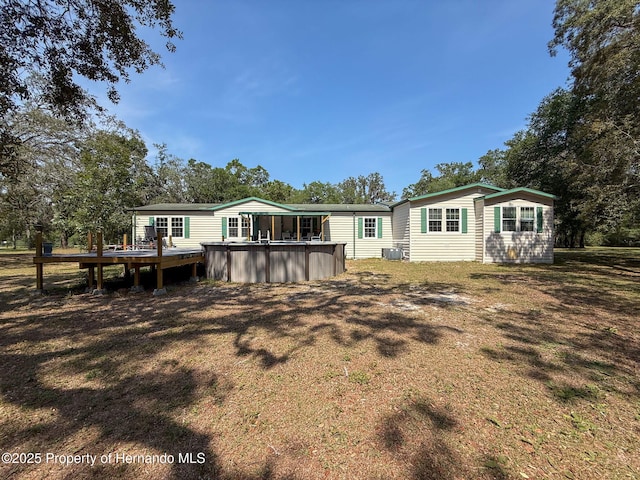 16173 Wiscon Rd, Brooksville, FL 34601 - rear view of house featuring a deck, a hot tub, and view of wooded area