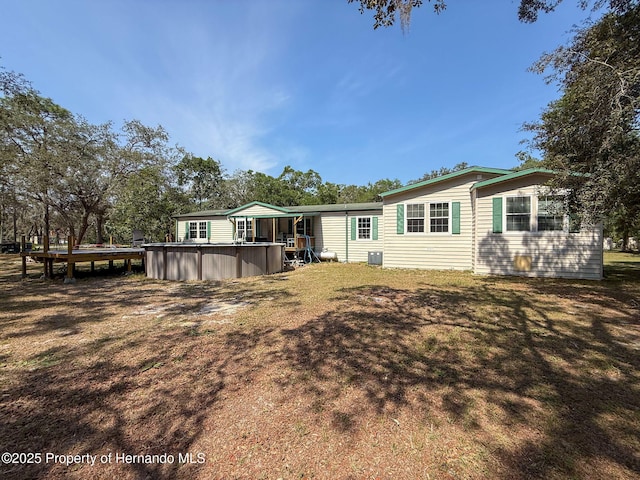 16173 Wiscon Rd, Brooksville, FL 34601 - rear view of house with an outdoor pool, central AC unit, and a yard