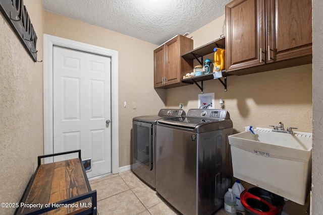 12371 Glen Haven St, Spring Hill, FL 34609 - laundry room with cabinet space, separate washer and dryer, light tile patterned flooring, a textured ceiling, and a textured wall