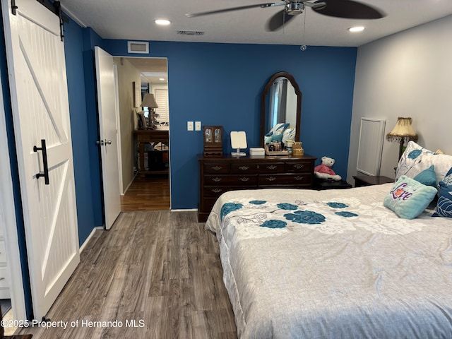 15693 Brookridge Blvd, Brooksville, FL 34613 - bedroom featuring wood finished floors, a barn door, a ceiling fan, and recessed lighting