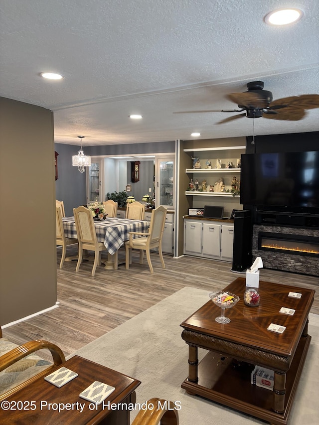 15693 Brookridge Blvd, Brooksville, FL 34613 - living room featuring ceiling fan, a textured ceiling, light wood-style flooring, recessed lighting, and a chandelier