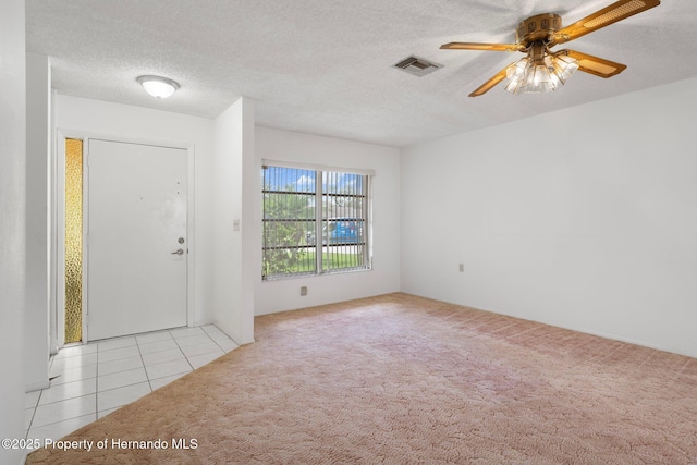 10820 Hachita Dr, Port Richey, FL 34668 - carpeted entrance foyer featuring ceiling fan, tile patterned floors, and a textured ceiling