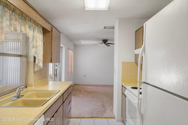 10820 Hachita Dr, Port Richey, FL 34668 - kitchen with white appliances, a sink, light carpet, light countertops, and a textured ceiling