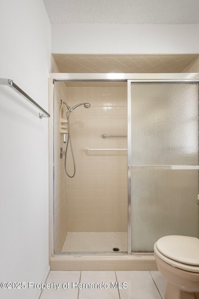 10820 Hachita Dr, Port Richey, FL 34668 - bathroom featuring a stall shower, toilet, and tile patterned flooring