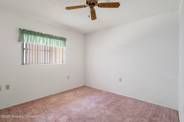 10820 Hachita Dr, Port Richey, FL 34668 - carpeted empty room featuring a ceiling fan, a textured ceiling, and baseboards