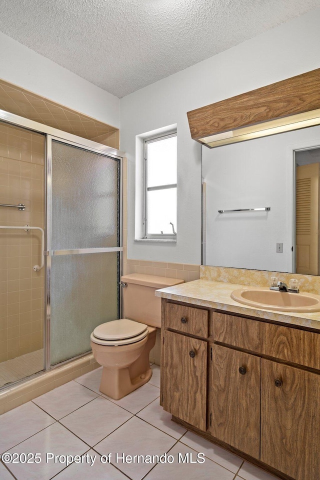 10820 Hachita Dr, Port Richey, FL 34668 - full bath with tile patterned flooring, a shower stall, toilet, a textured ceiling, and vanity