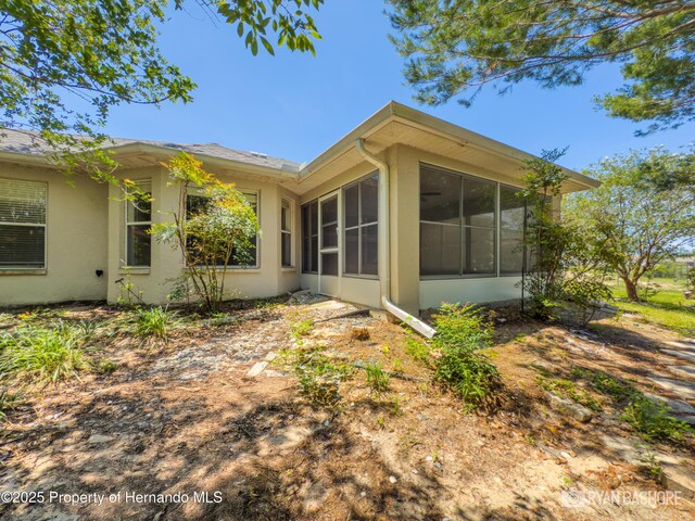 3095 Coronet Ct, Spring Hill, FL 34609 - view of side of property with a sunroom and stucco siding