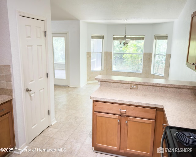3095 Coronet Ct, Spring Hill, FL 34609 - kitchen featuring a chandelier, decorative light fixtures, brown cabinets, light countertops, and black / electric stove