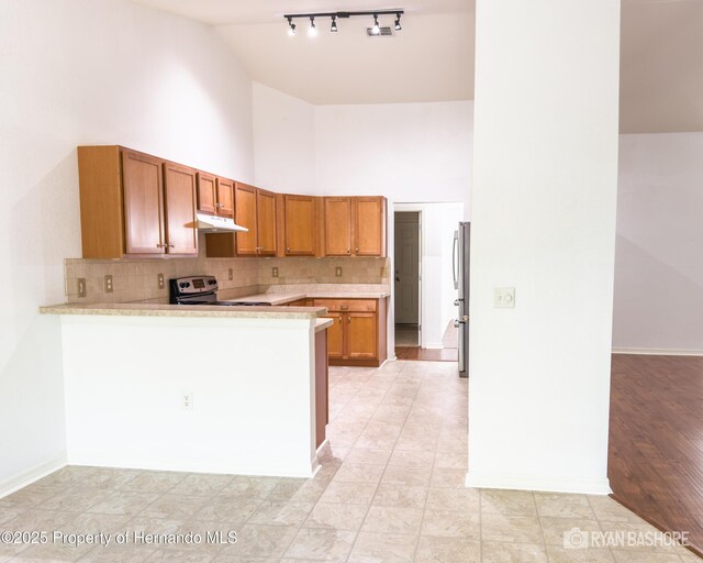 3095 Coronet Ct, Spring Hill, FL 34609 - kitchen featuring electric range oven, high vaulted ceiling, light countertops, a peninsula, and decorative backsplash
