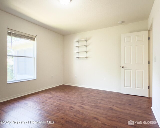 3095 Coronet Ct, Spring Hill, FL 34609 - spare room with dark wood-style flooring, baseboards, and a smoke detector