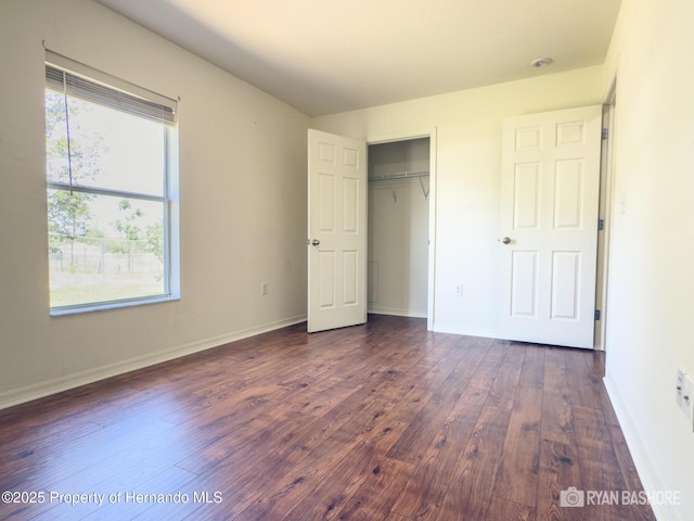 3095 Coronet Ct, Spring Hill, FL 34609 - unfurnished bedroom featuring dark wood-style flooring, baseboards, and a closet