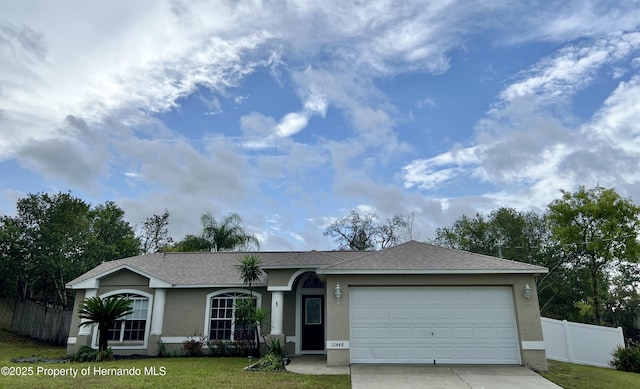 10448 Canary Ave, Weeki Wachee, FL 34613 - ranch-style house with concrete driveway, stucco siding, an attached garage, and a shingled roof