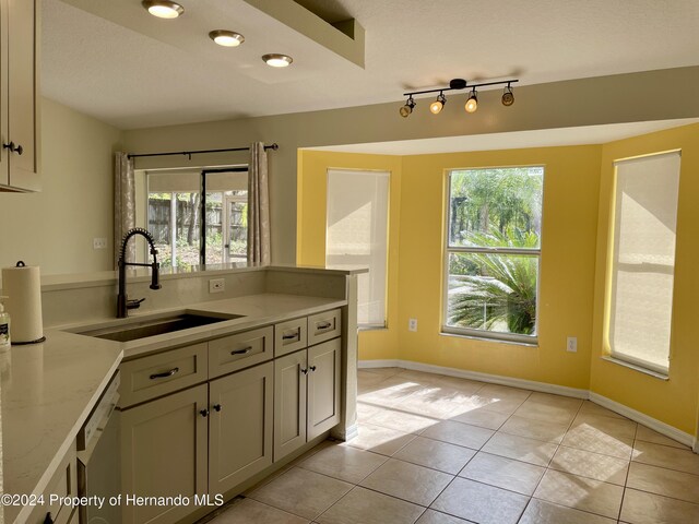 10448 Canary Ave, Weeki Wachee, FL 34613 - kitchen featuring a sink, stainless steel dishwasher, light tile patterned floors, baseboards, and a peninsula