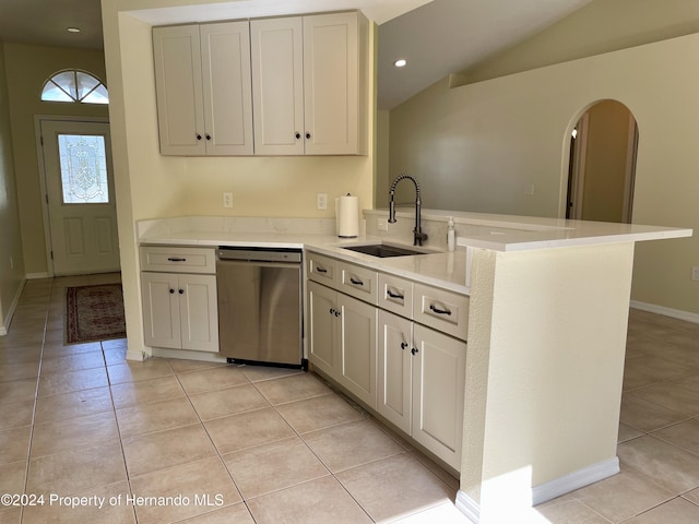 10448 Canary Ave, Weeki Wachee, FL 34613 - kitchen featuring dishwasher, a sink, lofted ceiling, light tile patterned flooring, and a peninsula