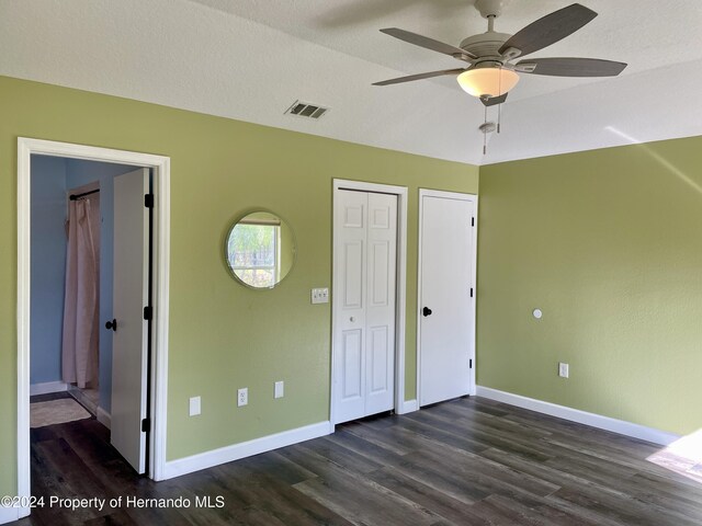 10448 Canary Ave, Weeki Wachee, FL 34613 - unfurnished bedroom with dark wood-style flooring, baseboards, and a ceiling fan