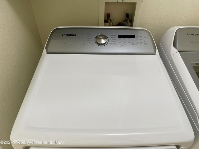 10448 Canary Ave, Weeki Wachee, FL 34613 - laundry view of washing machine and clothes dryer and a textured wall
