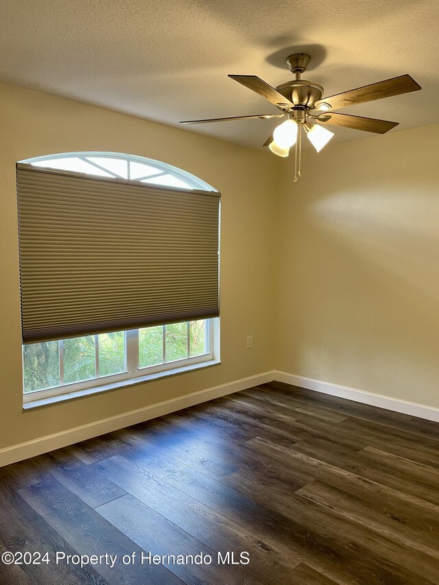 10448 Canary Ave, Weeki Wachee, FL 34613 - unfurnished room featuring dark wood-style floors, baseboards, and ceiling fan