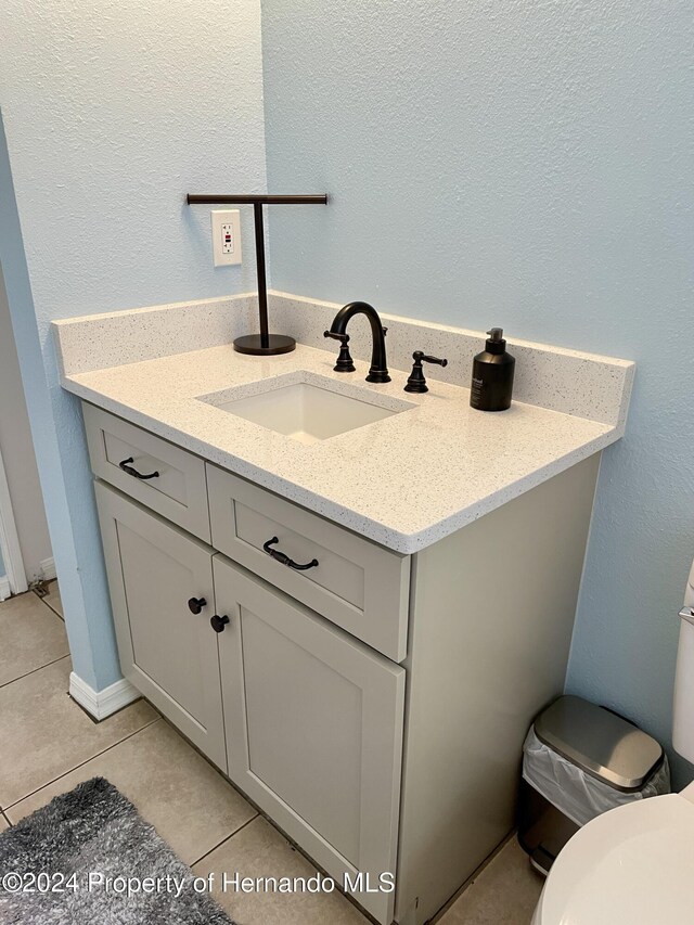10448 Canary Ave, Weeki Wachee, FL 34613 - bathroom with tile patterned flooring, toilet, and vanity