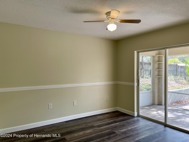 10448 Canary Ave, Weeki Wachee, FL 34613 - empty room with dark wood-style floors, baseboards, a textured ceiling, and a ceiling fan