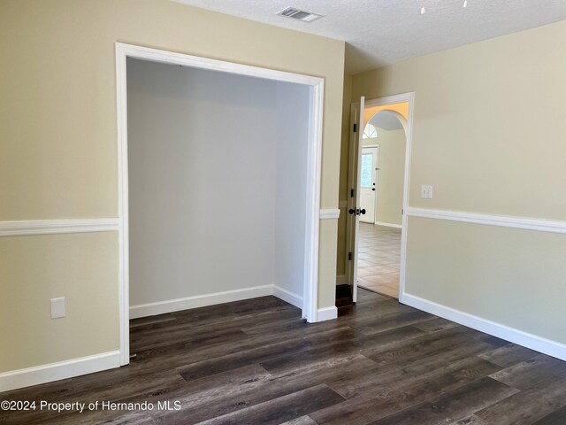 10448 Canary Ave, Weeki Wachee, FL 34613 - unfurnished room with dark wood finished floors, arched walkways, and baseboards