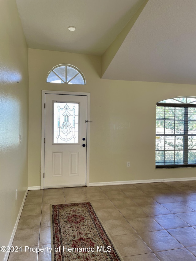 10448 Canary Ave, Weeki Wachee, FL 34613 - entrance foyer with light tile patterned floors, healthy amount of natural light, baseboards, and arched walkways