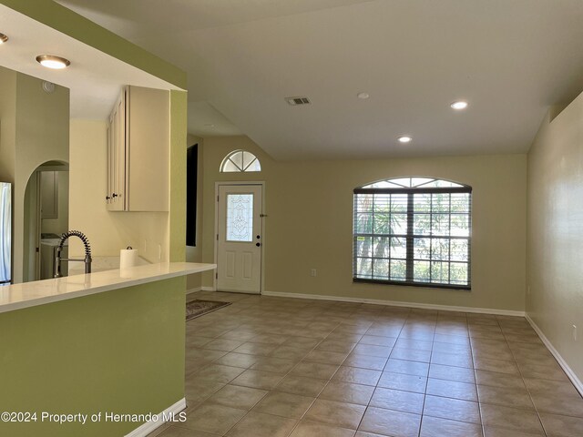 10448 Canary Ave, Weeki Wachee, FL 34613 - kitchen featuring light countertops, light tile patterned flooring, arched walkways, baseboards, and recessed lighting