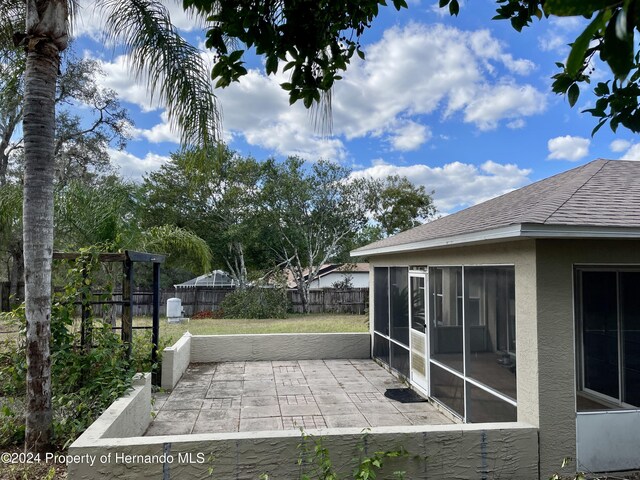 10448 Canary Ave, Weeki Wachee, FL 34613 - view of patio featuring a fenced backyard and a sunroom