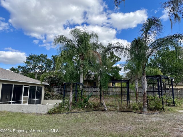 10448 Canary Ave, Weeki Wachee, FL 34613 - view of yard featuring a sunroom and fence