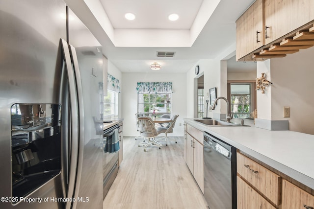 2183 Westchester Blvd, Spring Hill, FL 34606 - kitchen featuring appliances with stainless steel finishes, a sink, light wood-type flooring, light countertops, and a raised ceiling