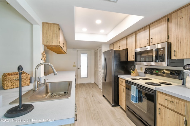 2183 Westchester Blvd, Spring Hill, FL 34606 - kitchen featuring stainless steel appliances, light wood-style flooring, light brown cabinets, light countertops, and a raised ceiling