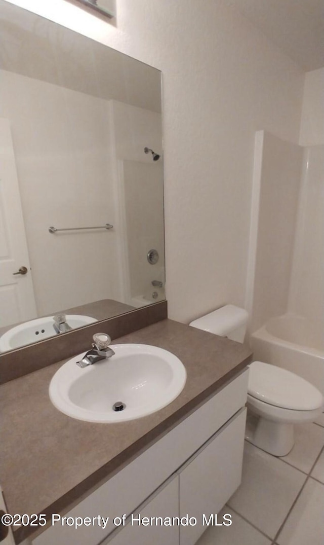 4035 Jason Rd, Spring Hill, FL 34608 - bathroom featuring vanity, bathtub / shower combination, tile patterned floors, and toilet