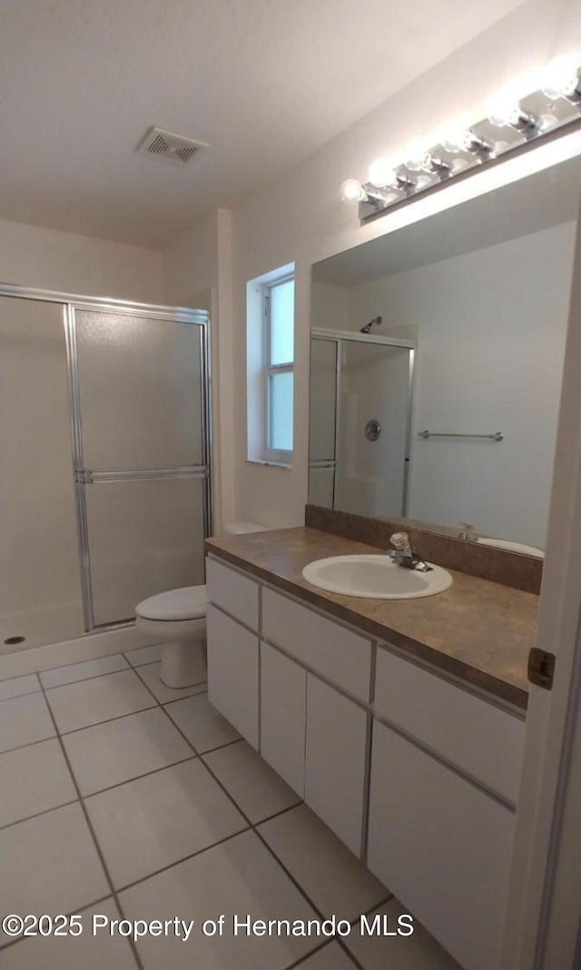 4035 Jason Rd, Spring Hill, FL 34608 - bathroom with vanity, tile patterned flooring, a stall shower, and toilet