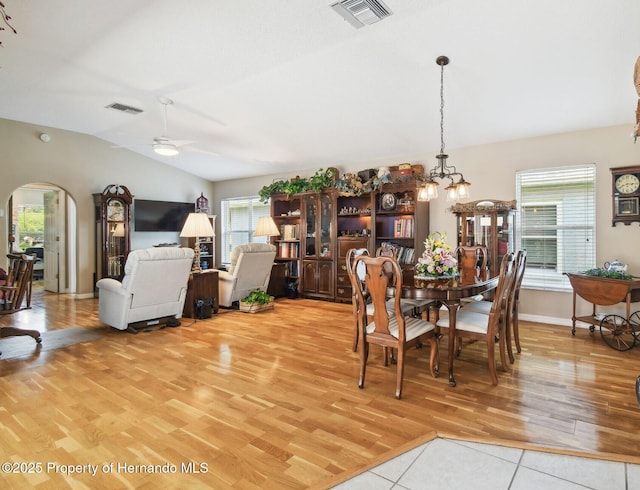 11752 Wheatfield Loop, Hudson, FL 34667 - dining space with lofted ceiling, light wood-style flooring, arched walkways, a ceiling fan, and a chandelier