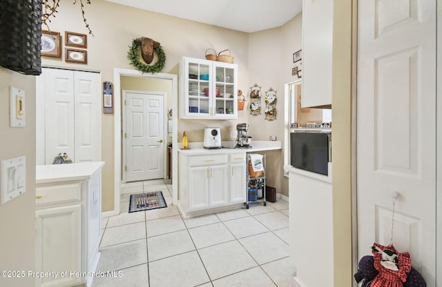 11752 Wheatfield Loop, Hudson, FL 34667 - kitchen featuring light tile patterned floors, white cabinets, and light countertops