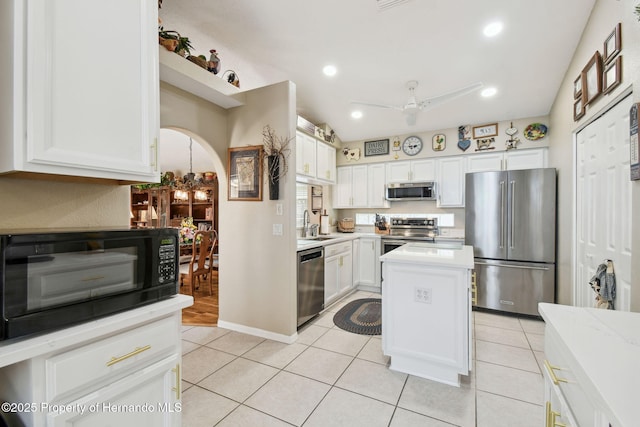 11752 Wheatfield Loop, Hudson, FL 34667 - kitchen featuring appliances with stainless steel finishes, white cabinets, light countertops, a kitchen island, and arched walkways