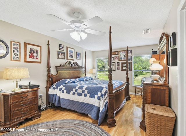 11752 Wheatfield Loop, Hudson, FL 34667 - bedroom with light wood-type flooring, a textured ceiling, and ceiling fan