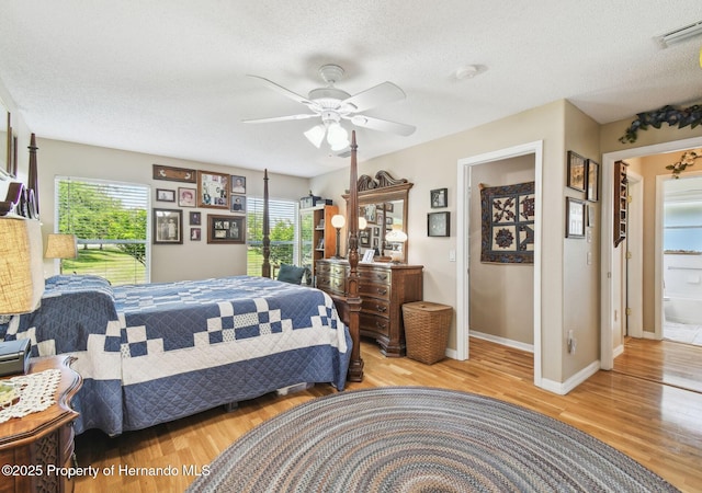 11752 Wheatfield Loop, Hudson, FL 34667 - bedroom featuring a textured ceiling, wood finished floors, baseboards, and a ceiling fan