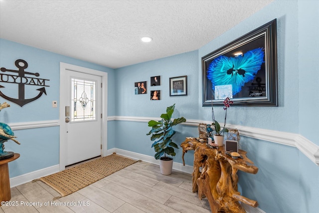 4387 6th Isle Dr, Hernando Beach, FL 34607 - foyer featuring a textured ceiling, wood finished floors, and baseboards