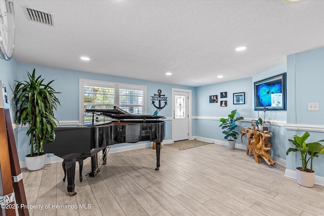4387 6th Isle Dr, Hernando Beach, FL 34607 - sitting room featuring a textured ceiling, wood finished floors, recessed lighting, and baseboards