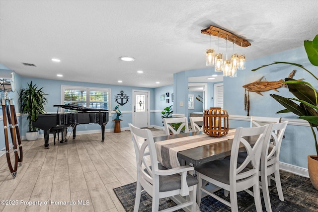 4387 6th Isle Dr, Hernando Beach, FL 34607 - dining space featuring light wood finished floors, a textured ceiling, recessed lighting, baseboards, and a chandelier