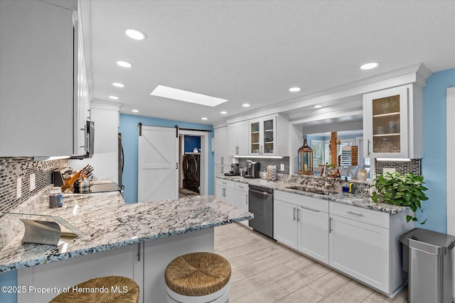 4387 6th Isle Dr, Hernando Beach, FL 34607 - kitchen featuring dishwasher, a sink, decorative backsplash, glass insert cabinets, and recessed lighting