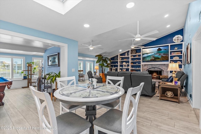 4387 6th Isle Dr, Hernando Beach, FL 34607 - dining room with light wood-style floors, lofted ceiling, healthy amount of natural light, a fireplace, and recessed lighting