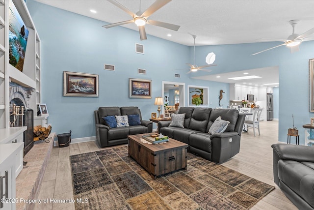 4387 6th Isle Dr, Hernando Beach, FL 34607 - living area featuring ceiling fan, a brick fireplace, light wood-style floors, high vaulted ceiling, and baseboards