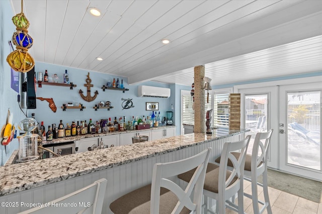 4387 6th Isle Dr, Hernando Beach, FL 34607 - kitchen with a wall mounted air conditioner, white cabinetry, plenty of natural light, recessed lighting, and light stone countertops